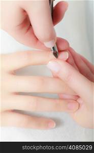 Close up of hands. Beautician trimming cuticles of female client. Manicure and skincare. Woman in spa beauty salon.