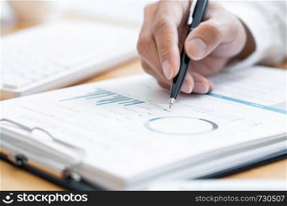 Close-up of hands Businessman reading and writing with pen signing contract over document for Completing Application Form at work in office