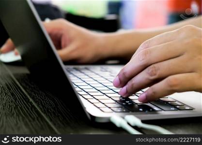 Close-up of hands of businessman typing on laptop keyboard 