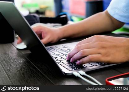 Close-up of hands of businessman typing on laptop keyboard 