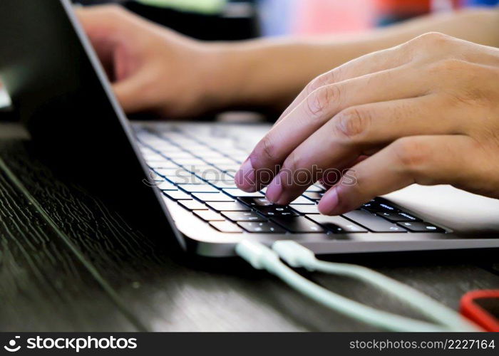 Close-up of hands of businessman typing on laptop keyboard 