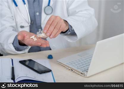 close up of hands of doctor with pills