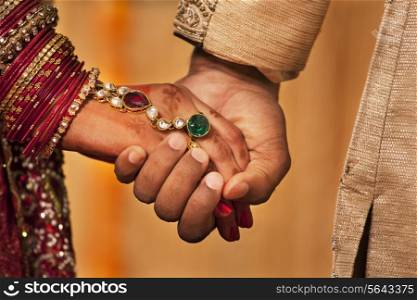 Close-up of hands of newly married Indian couple