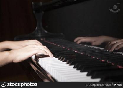 Close-up of hands playing the piano