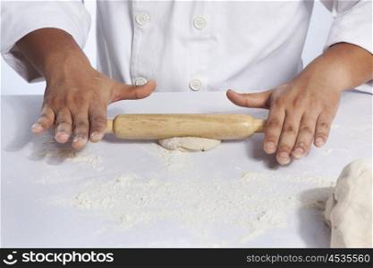 Close-up of hands rolling dough