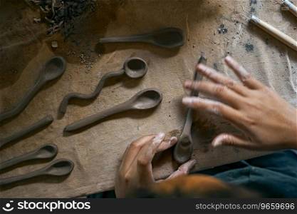 Close up of hands shaping a small clay spoon . Close up of hands shaping ceramic
