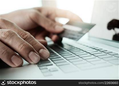 close up of hands using laptop and holding credit card  as Online shopping concept                    