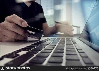close up of hands using laptop and holding credit card as Online shopping concept