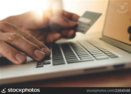 close up of hands using laptop and holding credit card with social media diagram as Online shopping concept