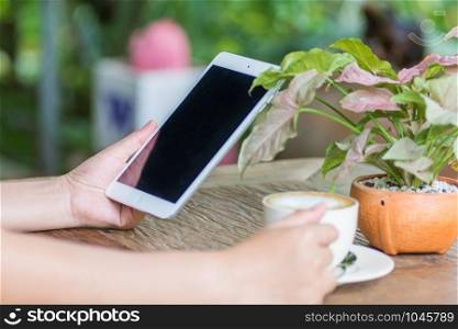 Close up of hands woman using tablet in cafe