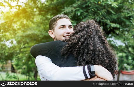 Close up of happy couple hugging in nature, Close up of smiling teenage couple hugging, Teenage couple hugging outdoors