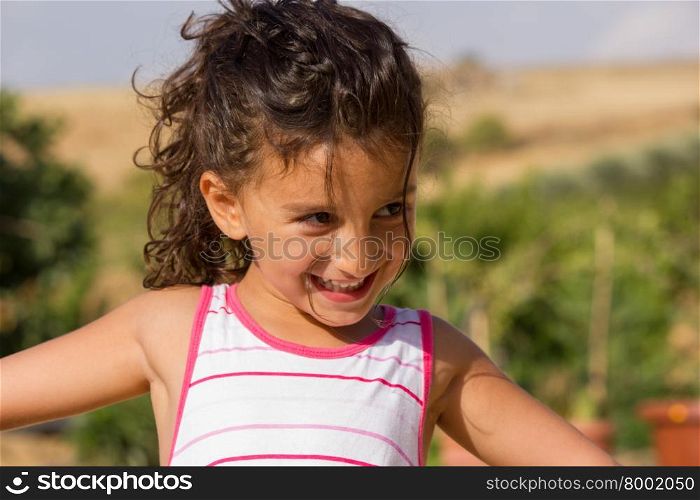 Close-up of happy little girl playing in the garden