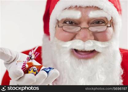 Close-up of happy Santa Claus offering chocolates