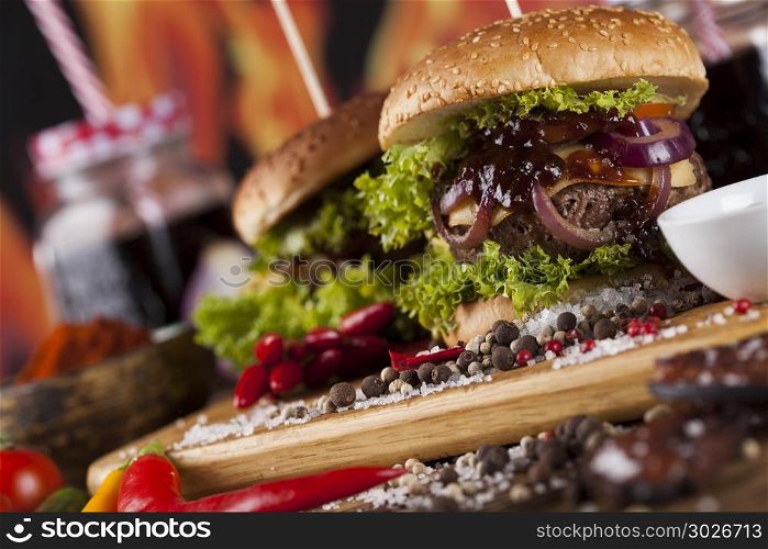 Close-up of home made burgers, wooden desk background. Home made hamburge, wooden desk background