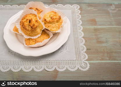 Close up of homemade coconut macaroons, cookie recipe in the oven on rustic wooden background. Top view with copy space.