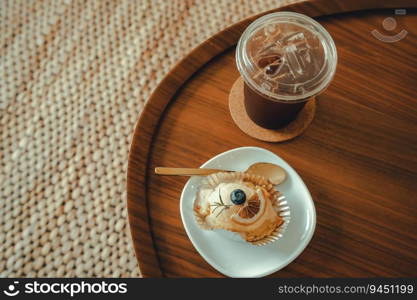 Close-up of Homemade white orange cake and Americano iced coffee or black coffee in wood desk office desk in coffee shop at the cafe in garden,during business work concept