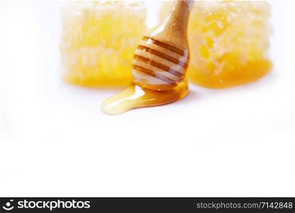 Close up of honey on white background with wooden dipper and honeycomb yellow sweet nature