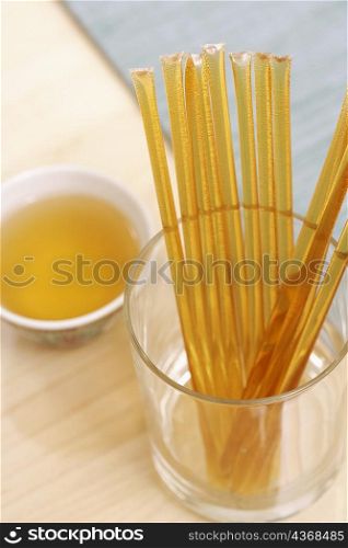 Close-up of honey sachets in a glass with a bowl of aromatherapy oil on the table