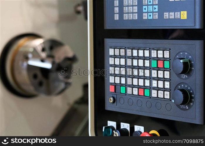 Close up of horizontal cnc turn mill machine with open door. Selective focus on control panel.