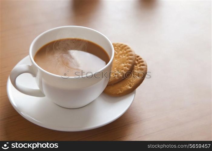 Close-up of hot tea and biscuits on table