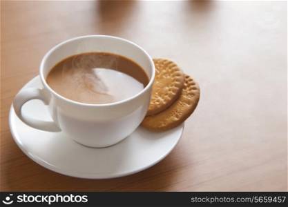 Close-up of hot tea and biscuits on table
