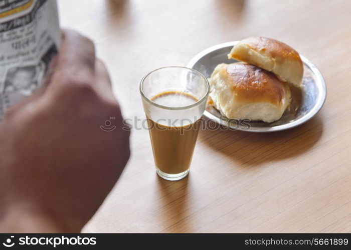 Close-up of hot tea and pav on table