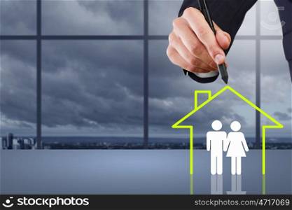 Close up of human hand drawing happy family and real estate concept. House of your dream