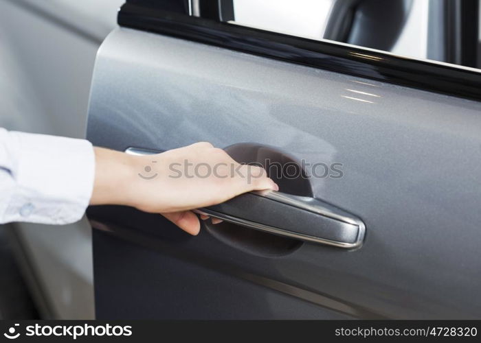 Close up of human hand opening door of car