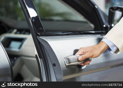 Close up of human hand opening door of car