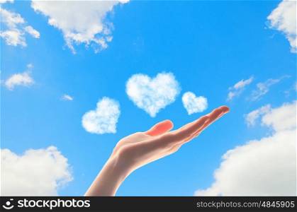 Close up of human hand with hearts. Close up of human hand holding cloudy hearts