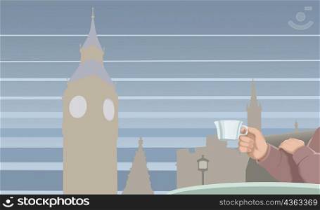 Close-up of human hands holding a cup with buildings and a tower in the background, Big Ben, London, England