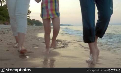 Close up of human legs walking on summer beach, bodypath