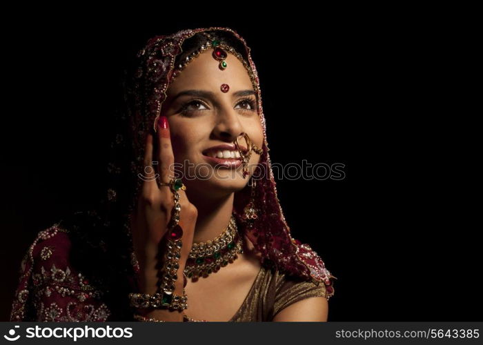 Close-up of Indian bride in wedding attire and jewelery