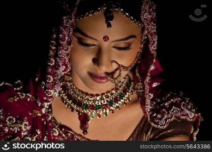 Close-up of Indian bride in wedding attire and jewelery