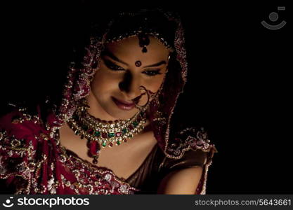 Close-up of Indian bride in wedding attire and jewelery