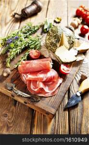 Close up of italian antipasto - assorted plate with cheese, ham, prosciutto, tomato and aroma herb