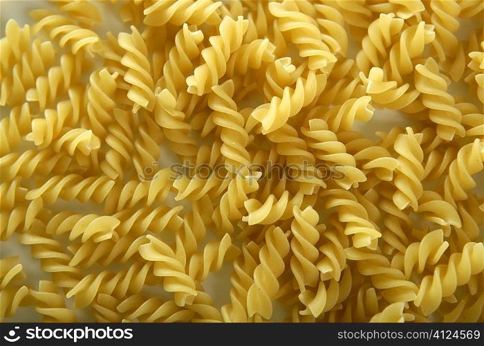 Close-up of italian spiral yellow pasta texture as background