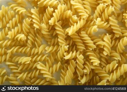 Close-up of italian spiral yellow pasta texture as background