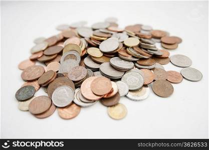 Close-up of large group of coins over white background