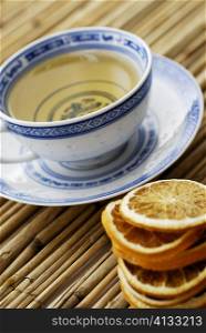 Close-up of lemon slices and a cup of herbal tea