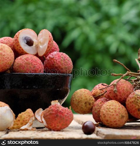 Close up of litchi fruit or lychee fruits, a tropical agriculture product at Luc Ngan, Bac Giang, Vietnam, basket of Vai thieu on green background