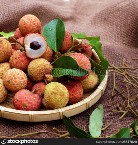 Close up of litchi fruit or lychee fruits, a tropical agriculture product at Luc Ngan, Bac Giang, Vietnam, basket of Vai thieu on brown background