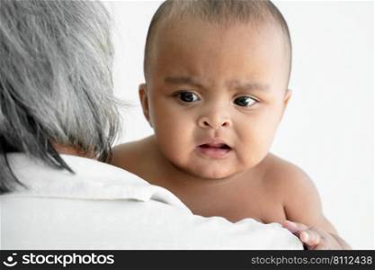 Close up of Little African newborn baby girl enjoy with white haired grandfather carrying her on shoulder. Love and close relationship in family concept. White background