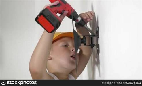 Close-up of little boy working with electric screwdriver