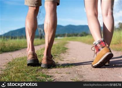 Close up of lower legs of two travelers walking along path in nature. Hiking and Camping concept. Backpacker an Tourist concept. Outdoors activity and adventure theme.