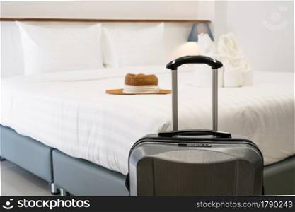 Close up of luggage in hotel room. Comfortable hotel bedroom in cozy style. Holiday, vacation, business trip concept.