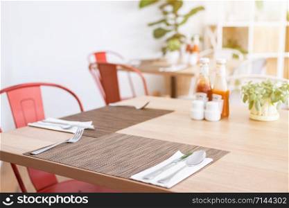 Close-up of luxurious spoon and fork, flower vaseson, sauce bottle the dining table decoration in hotel