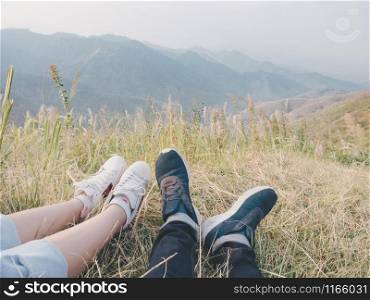 Close-up of male and female?s feet relaxing in nature and landscapes beautiful mountains.
