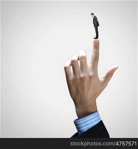 Close up of male businessman. Close up of male businessman pointing at miniature of man