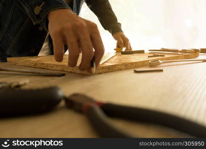 Close-up of male carpenter holding a measure tape in workshop